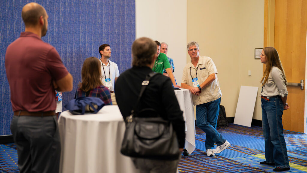 Ross Ambrose talking with colleagues at an industry event